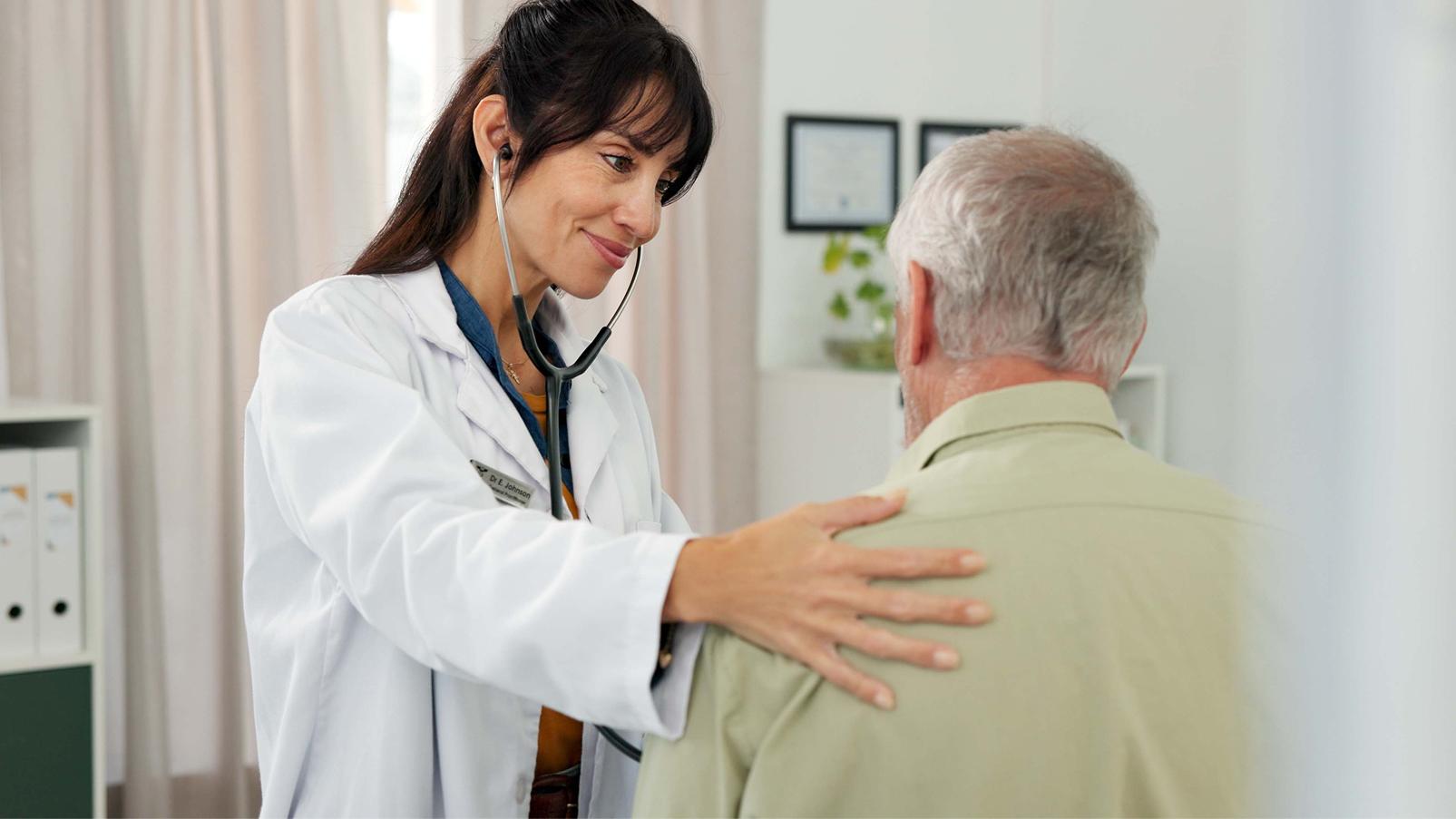 Professionista sanitario che esegue un controllo con lo stetoscopio sul torace di una persona anziana.
