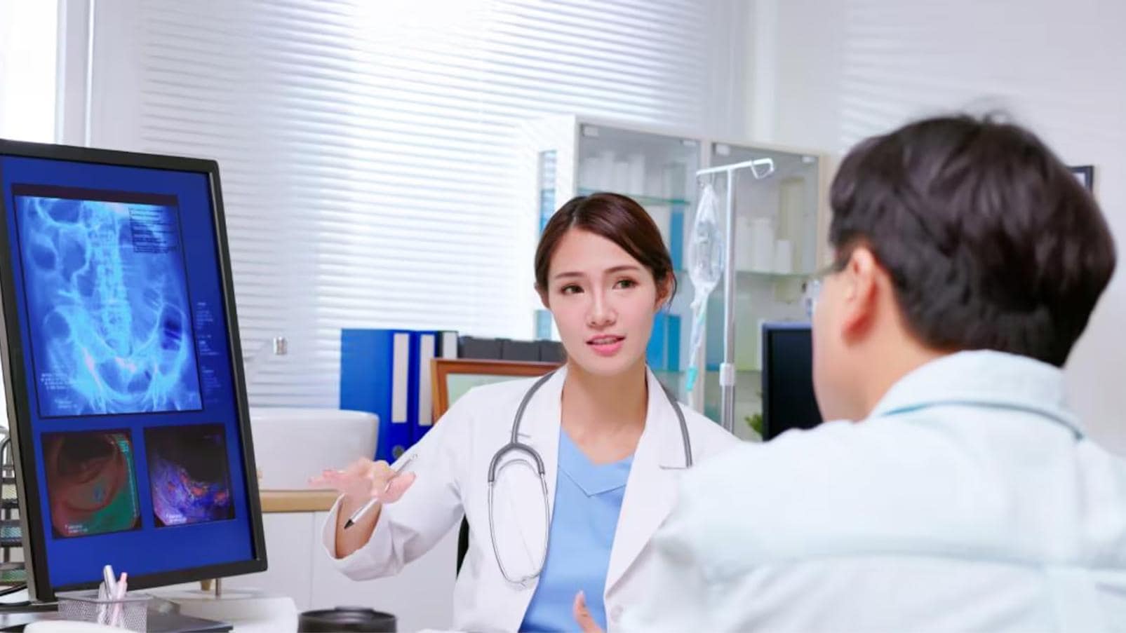 Professionista sanitario analizza immagini diagnostiche insieme a una persona assistita.