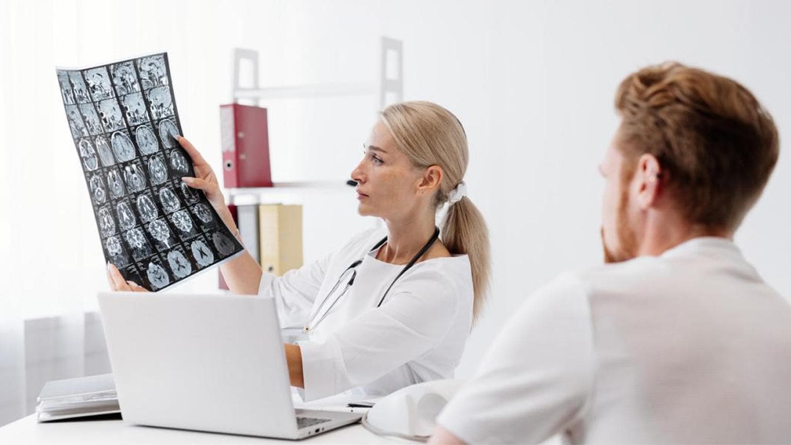 Professionista sanitario esamina un'immagine radiografica durante una visita di approfondimento.