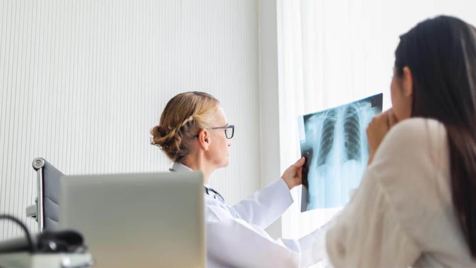 Professionista sanitario esamina un'immagine radiografica durante una visita di approfondimento.